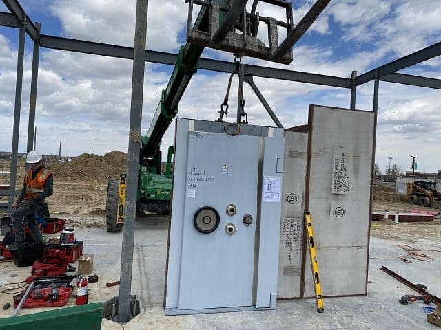 A vault door being set in place on site